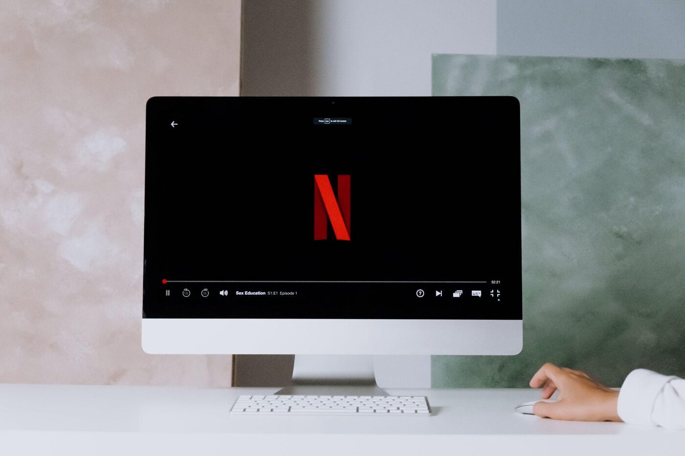 A desktop computer screen displaying a streaming service home page on a home office desk
